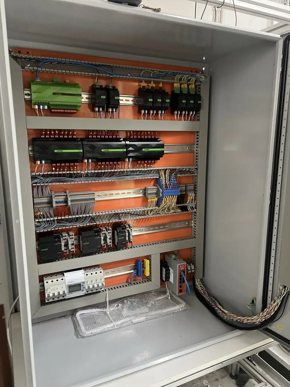 Open control cabinet showing the Loxone automation hardware and field wiring